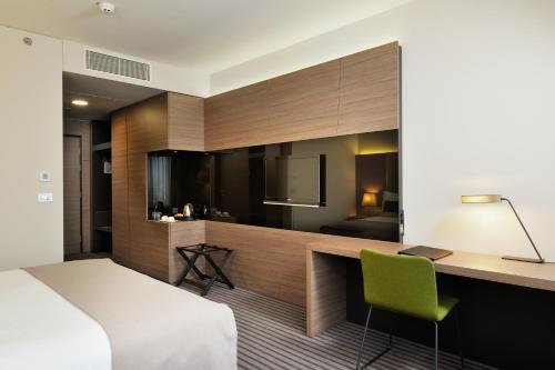 a bedroom with a bed and a desk and a kitchen at Radisson Blu Plaza Hotel Ljubljana in Ljubljana