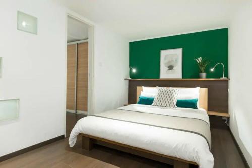 a bedroom with a large bed with a green headboard at Budapest Downtown Museum Apartments in Budapest