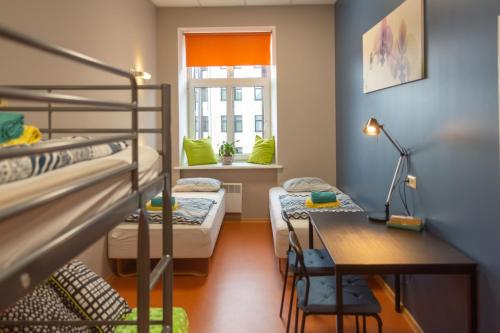 a dorm room with two bunk beds and a desk at Liberty Airy in Rīga