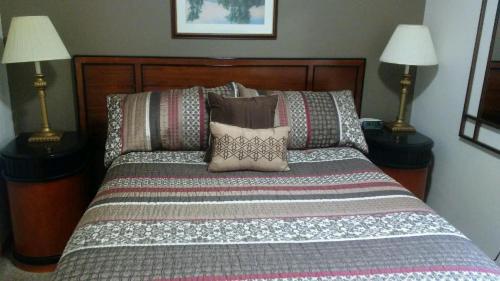 a bedroom with a bed with pillows and two lamps at Nauvoo Vacation Condos and Villas in Nauvoo