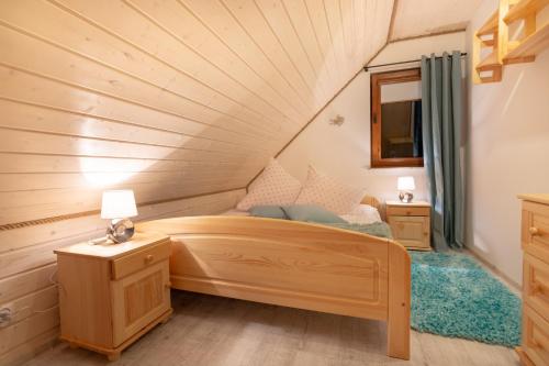 a small bedroom with a bed in a attic at Chaty Anety Domki Całoroczne in Solina