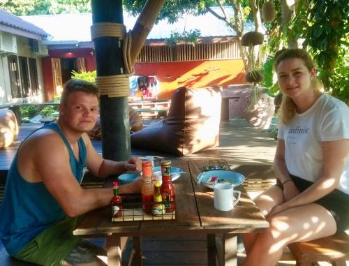 a man and a woman sitting at a picnic table at Aha Lanta Cozy Hostel in Ko Lanta