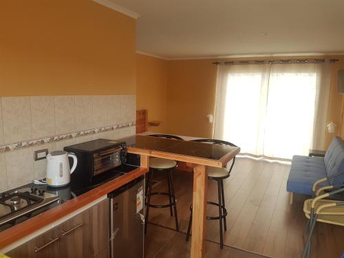a kitchen with a counter with a microwave and a stove at Cabaña Vista Bahia Algarrobo in Algarrobo