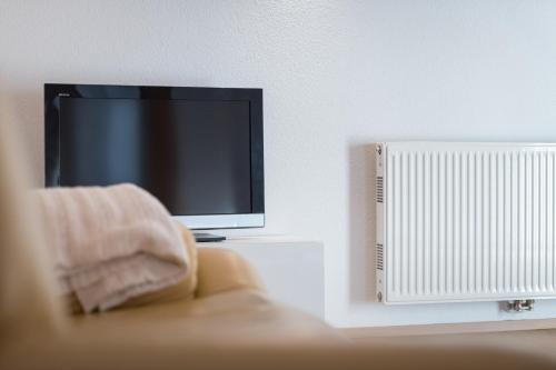 a tv sitting on a table next to a radiator at Alpinloft Tirol in Bad Häring