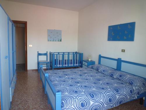 ein Schlafzimmer mit einem blauen Bett in einem Zimmer in der Unterkunft Apartment in Eraclea Mare 25695 in Eraclea Mare