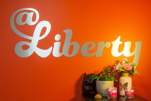 an orange wall with a sign that reads a buffet at Liberty Airy in Rīga