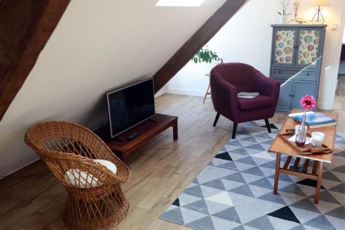 salon z telewizorem i krzesłem w obiekcie Le Coquillage w mieście Granville