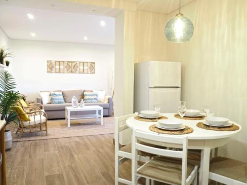 a kitchen and living room with a table and a refrigerator at Pé N'Areia - Beach Apartment with Terrace in Viana do Castelo