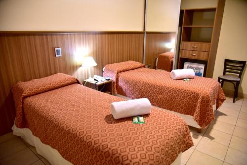 a hotel room with two beds and a mirror at Hotel Confianza in Corrientes