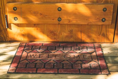 a welcome mat in front of a wooden door at Complejo Cabañas Quilamalen in Villarrica