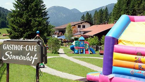 a park with a playground and a sign in the grass at Landgasthof Sonnenhof in Klais