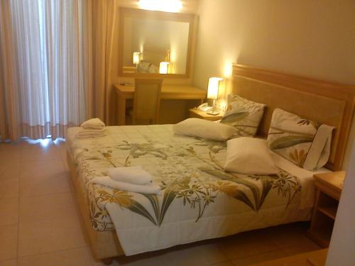 a bedroom with a large bed with towels on it at Glyfada Beach Hotel in Glyfada