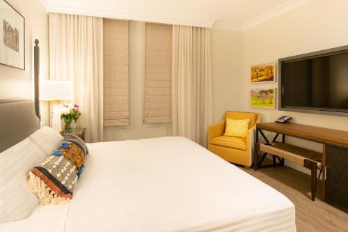 a bedroom with a large white bed and a desk at Hotel E in Santa Rosa