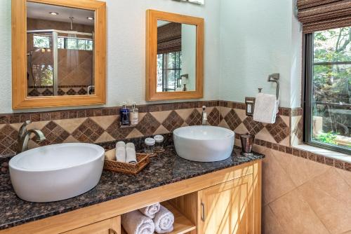 a bathroom with two sinks and two mirrors at Sheridan House Inn- Adult Only Accommodation in Williams