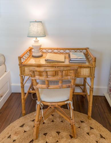 a wooden desk with a lamp and a chair at Eleven Bahama House in Harbour Island