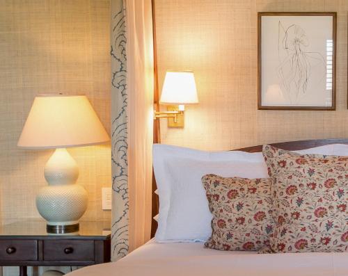 a bedroom with a bed with a lamp on a table at Eleven Bahama House in Harbour Island