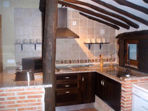 a kitchen with a sink and a stove top oven at Hotel La Casa Chacinera in Candelario
