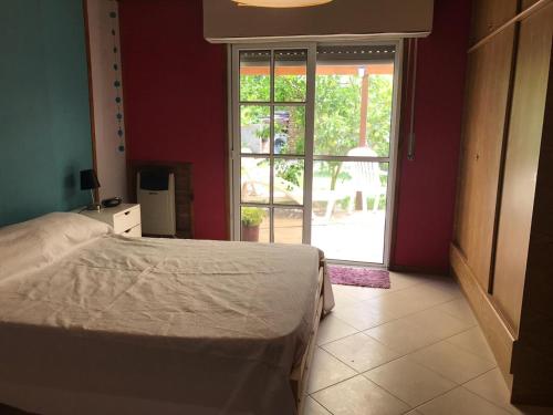 a bedroom with a bed and a sliding glass door at Casa Las Chulas in Ostende
