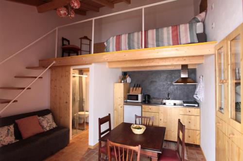 um pequeno apartamento com uma sala de jantar e cozinha com um loft em Casa das Minas em Minas de São Domingos