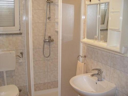 e bagno con servizi igienici, lavandino e doccia. di Two-Bedroom Apartment in Pula II a Veruda