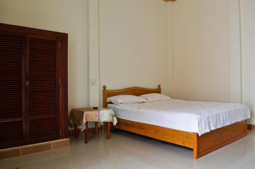 a bedroom with a bed and a table in a room at Ngoc Sang Guesthouse in Mui Ne
