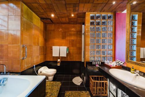 een badkamer met een toilet, een wastafel en een bad bij Mom Tri's Villa Royale - SHA Plus in Kata Beach