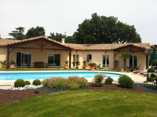 una casa con piscina en el patio en LE CLOS CASTEL - Gîte équipé en Casteljaloux