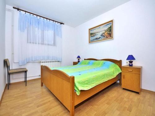 a bedroom with a bed and a chair and a window at Apartment Pula, Istria 18 in Veli Vrh