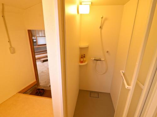 a small bathroom with a shower and a toilet at Inn the Camp in Kasaoka