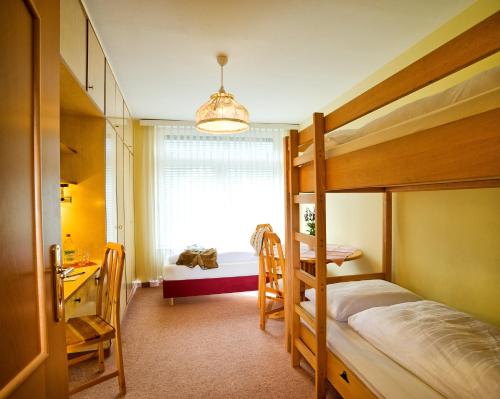a bedroom with a bunk bed and a desk and a window at Euro Youth Hotel & Krone in Bad Gastein