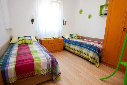 a bedroom with two beds and a window at Apartment Vrbnik 8 in Vrbnik