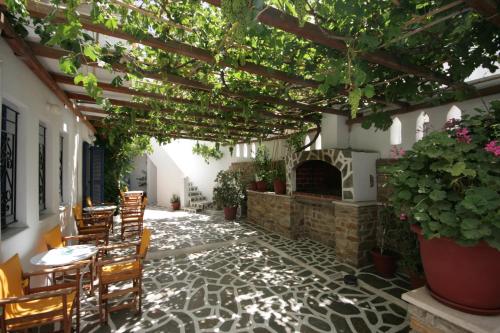 a patio with tables and chairs and a fireplace at Jasmine in Parikia