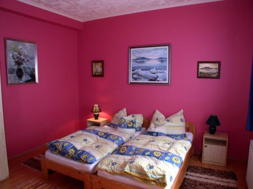 フォニョードにあるApartment Fonyod 25のピンクの壁のベッドルーム1室、ベッド1台(枕付)
