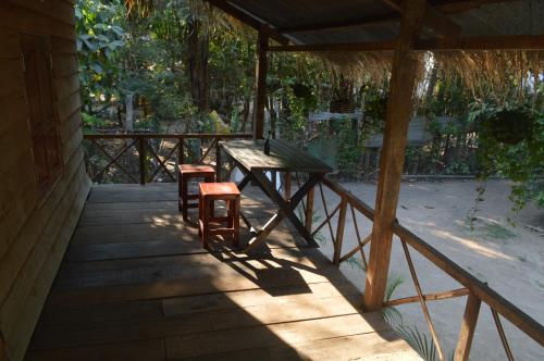 a wooden porch with a table and two stools at Sok Phen Homestay in Siem Reap