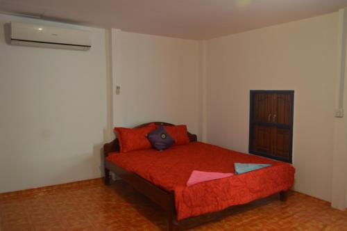 a bedroom with a bed with red sheets and a red blanket at Sok Phen Homestay in Siem Reap