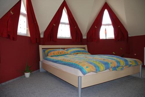 シオーフォクにあるApartment Siofok 18の赤い壁と窓のベッド付きのベッドルーム1室