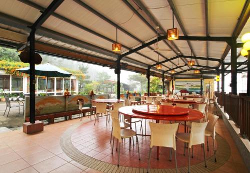 ein Restaurant mit Tischen und Stühlen und eine Terrasse in der Unterkunft Tian Xiu Mountain Village in Gukeng