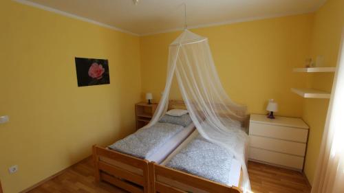 a bedroom with a bed with a mosquito net at Apartment Malinska, Primorje-Gorski Kotar 7 in Sveti Vid-Miholjice
