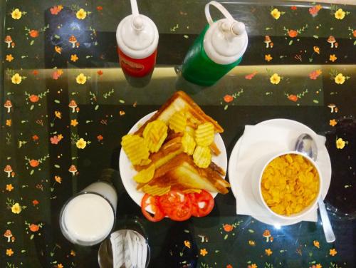 uma mesa com um prato de waffles, batatas fritas e bebidas em Hotel Vinayak Lifestyle Hotels em Lucknow