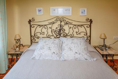 a bed with two pillows on it with two lamps at Apartahotel Trébede in Barro de Llanes