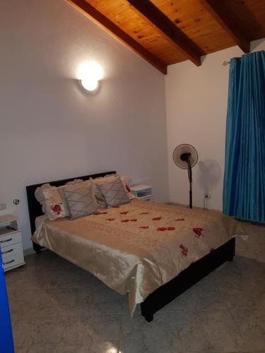 - une chambre avec un grand lit et un rideau bleu dans l'établissement Casa Azul SANTA MARIA Cape Verde, à Santa Maria