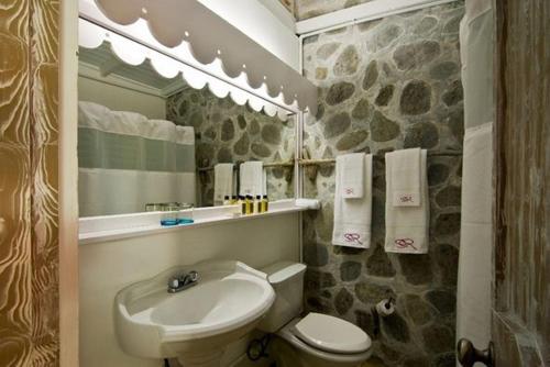 a bathroom with a sink and a toilet and a mirror at Sugar Reef Bequia - Adults Only in Crescent Beach
