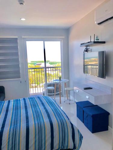 ein Schlafzimmer mit Bett und ein Balkon mit Tisch in der Unterkunft Explorer Suite 1004 in Bacolod City