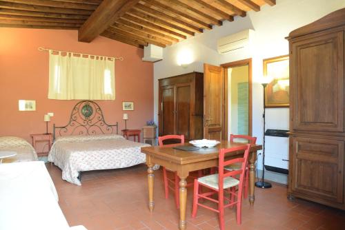 een slaapkamer met een bed en een tafel en stoelen bij B&B La corte di Stelio in Pisa
