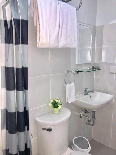 ein weißes Badezimmer mit Toilette und Waschbecken in der Unterkunft Explorer Suite 1004 in Bacolod City