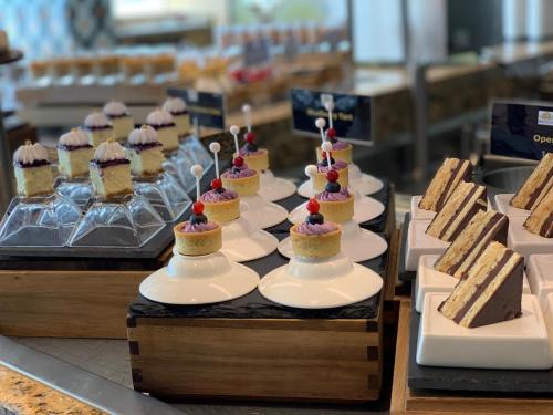 a display of cakes and desserts on plates on a table at Royal M Hotel Abu Dhabi by Gewan in Abu Dhabi