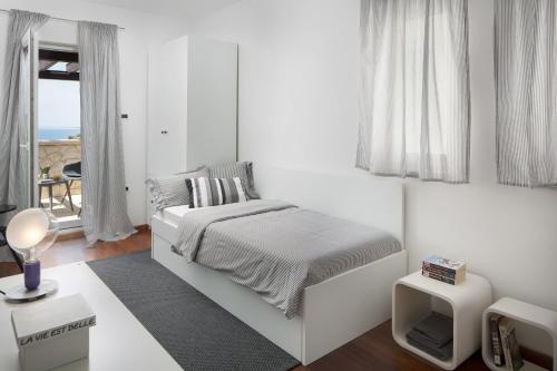 ein weißes Schlafzimmer mit einem Bett und einem Fenster in der Unterkunft Villa Pag in Mandre
