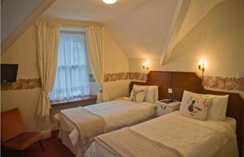 Habitación de hotel con 2 camas y ventana en Windermere Lynwood Guest House, en Windermere
