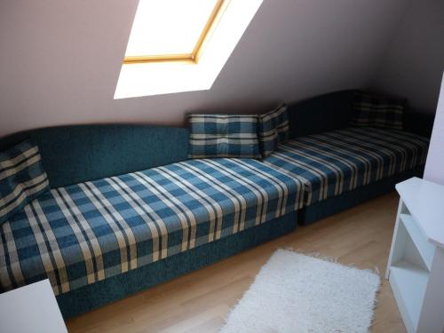 バラトンフェニヴェシュにあるApartment Balatonfenyves/Balaton 18381の窓付きの客室で、青いソファが備わります。
