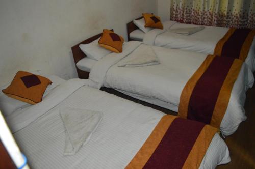 a group of three beds in a room at Holyland Guest House in Kathmandu